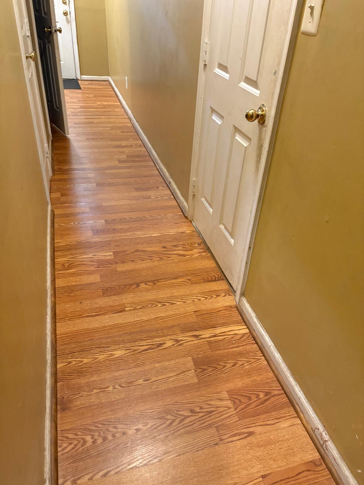 Wood-look plank flooring newly installed across a residential hallway