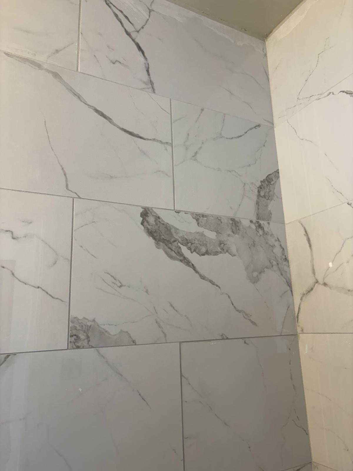 Marble-look porcelain tile installed on bathroom wall